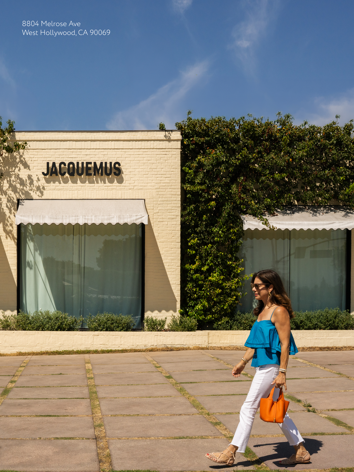 Natasha walking past the bright Jacquemus storefront